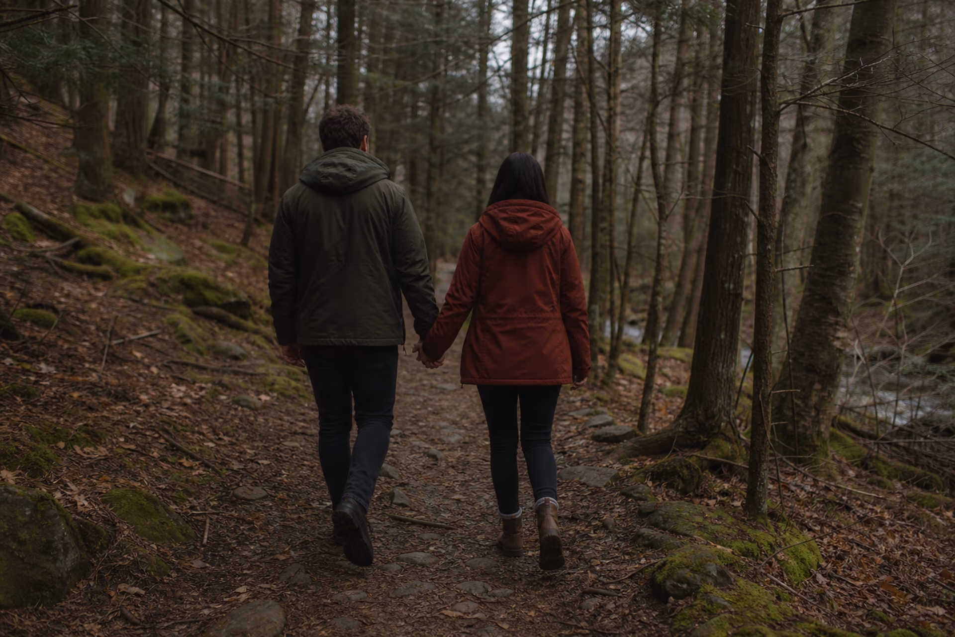 Olivia and James walking away together on a forest trail